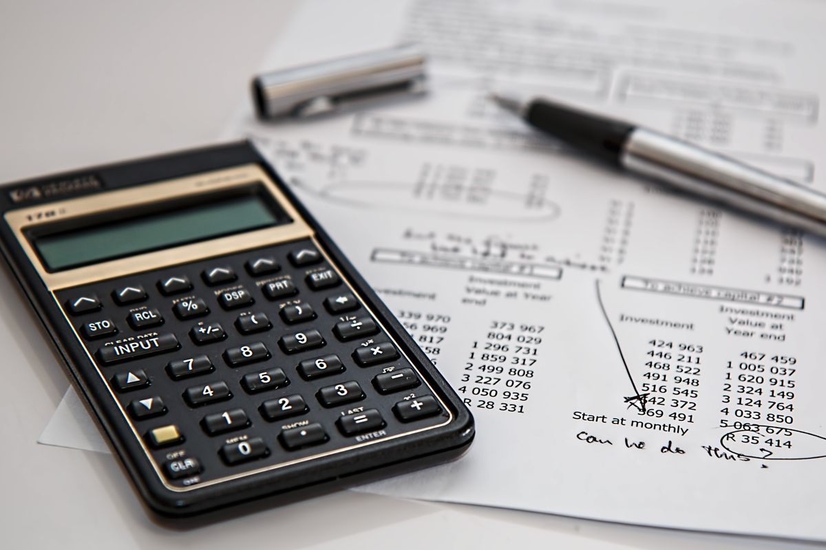 Calculator and financial documents representing payroll compliance